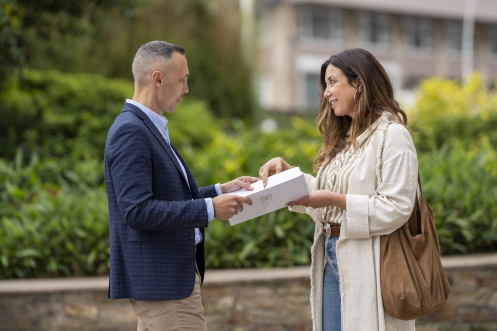 Paloma y Mario (agentes de la inmobiliaria) discutiendo sobre cómo vender una casa al mejor precio en A Coruña